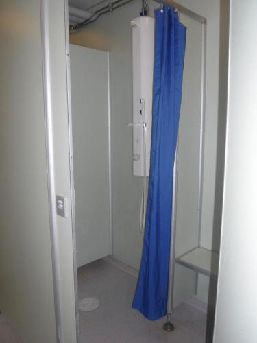 a room with a blue shower curtain and a chair at First Camp Enåbadet - Rättvik in Rättvik