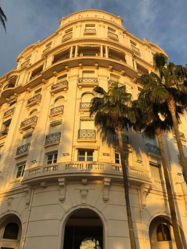 wysoki budynek z palmą przed nim w obiekcie PALACE ROOM CROISETTE w Cannes