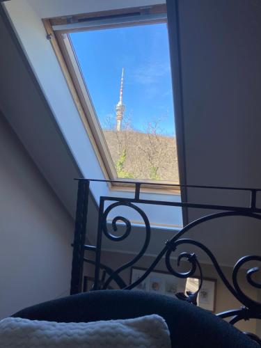 a room with a window with a view of a tv tower at Hilltop Wellness Villa-big garden, sauna, hot tube in Pécs