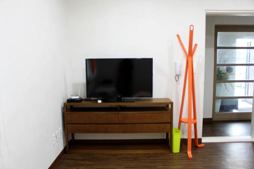 a flat screen tv sitting on top of a wooden dresser at Warak Guesthouse in Jeju