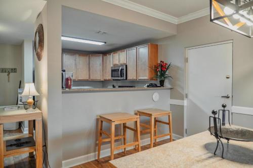 a kitchen with wooden cabinets and two stools at MVC - Unit 3707 - Sweet Wilderness in Pigeon Forge