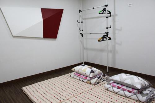 a room with two pillows on the floor next to a wall at Warak Guesthouse in Jeju