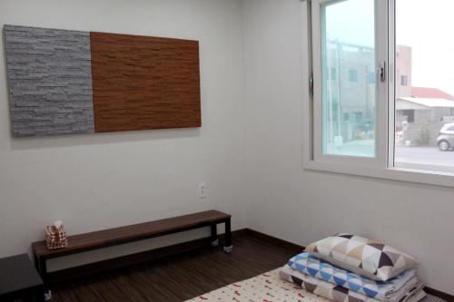 a room with a bench and a window at Warak Guesthouse in Jeju