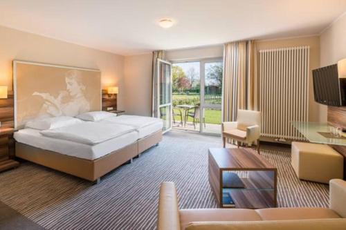 ein Schlafzimmer mit einem großen Bett und ein Wohnzimmer in der Unterkunft Balland's Hotel & Restaurant in Lindwedel