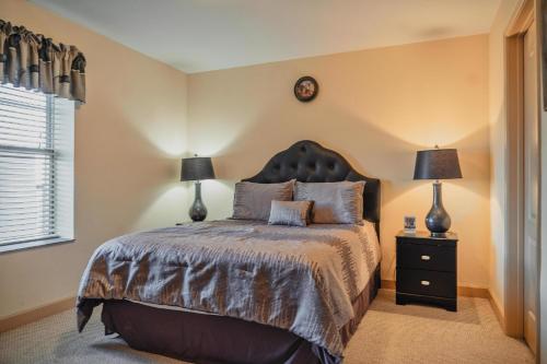 a bedroom with a bed with two lamps and a clock at MVC - Unit 3606 in Pigeon Forge