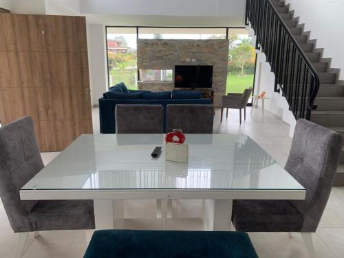 a dining room with a white table and chairs at Casa Campestre Altamira in Los Curos