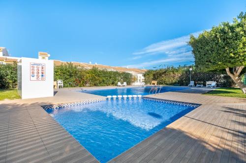 a swimming pool with blue water in a yard at Casa Dario in Gran Alacant