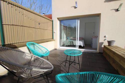 un patio con sillas y mesas y un dormitorio en Cocon à la campagne - Disney 20 min - Paris 40 min - 2 terrasses en Dammartin-sur-Tigeaux