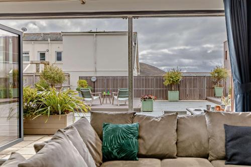 sala de estar con sofá en el patio en 2 Challacombe - Luxury Apartment at Byron Woolacombe, only 4 minute walk to Woolacombe Beach!, en Woolacombe