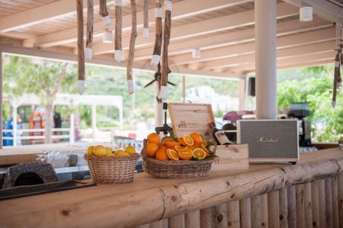 a counter with two baskets of oranges and a laptop at Soleil Village & Villas in Jal