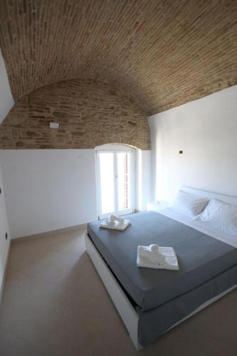 a bedroom with a bed with two towels on it at Casale Bernardino in Bernalda