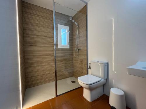 a bathroom with a toilet and a glass shower at Private Apartments Cala Canyelles in Lloret de Mar