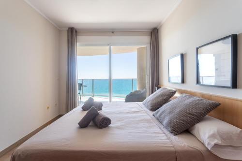 Paradero Rental B74- Vistas al Mar في كاليبي: غرفة نوم بسرير كبير مطلة على المحيط