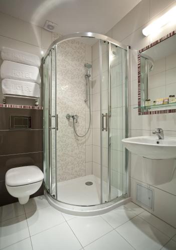 a bathroom with a shower and a toilet and a sink at Hotel Kazimierz in Krakow