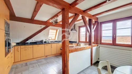 - une cuisine avec des plafonds en bois et des fenêtres dans une maison dans l'établissement Villa Louisa, à Zellenberg