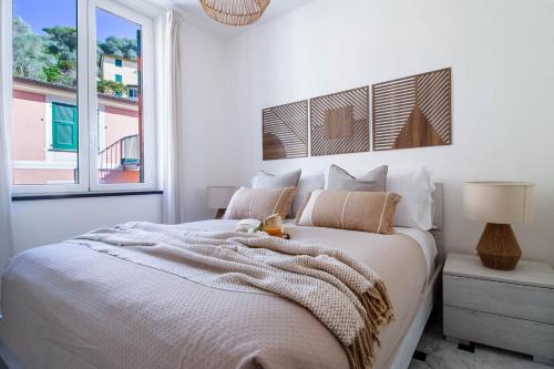 a white bedroom with a bed and a window at Olives Bay Terrace in Portofino in Portofino