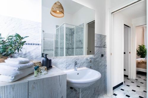 a white bathroom with a sink and a mirror at Olives Bay Terrace in Portofino in Portofino