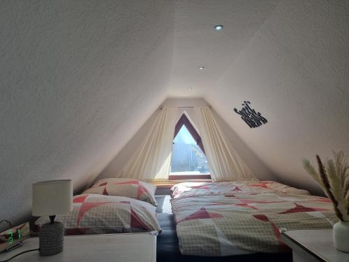 a attic bedroom with two beds and a window at Ostorfer See in Schwerin