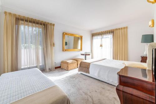 ein Hotelzimmer mit 2 Betten und einem Spiegel in der Unterkunft Qm na in Alvarelhos