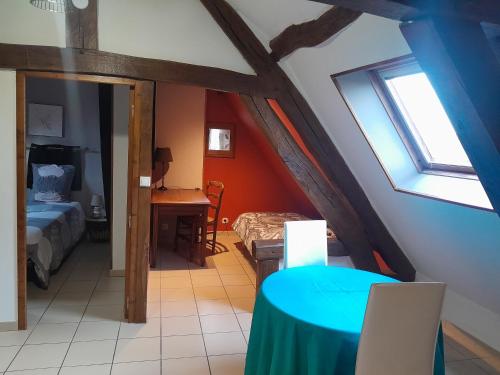 Zimmer mit einem Bett und einem Schreibtisch im Dachgeschoss in der Unterkunft La Mansarde: appartement tout confort à Vatan in Vatan