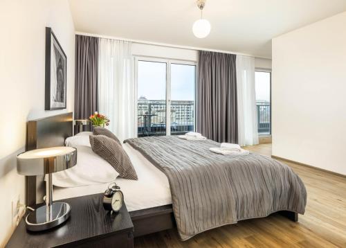 een slaapkamer met een groot bed en een groot raam bij Jimmy's Apartments Lory in Wenen