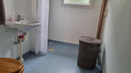 a bathroom with a sink and a trash can at Fageredsgården in Ullared