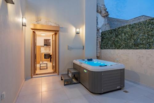 Erotokritos City Luxury Suites في مدينة ريثيمنو: حمام مع حوض جاكوزي في الغرفة