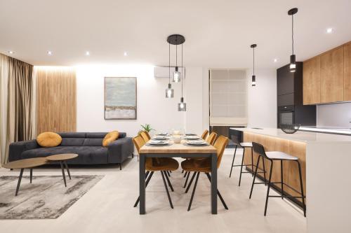 a kitchen and living room with a table and chairs at Leonardo Luxury Residence 2 Penthouse with jacuzzi in Zadar