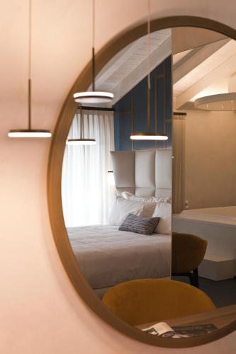 a mirror reflecting a bedroom with a bed in it at Vip's Motel Luxury Accommodation & Spa in Lonato del Garda