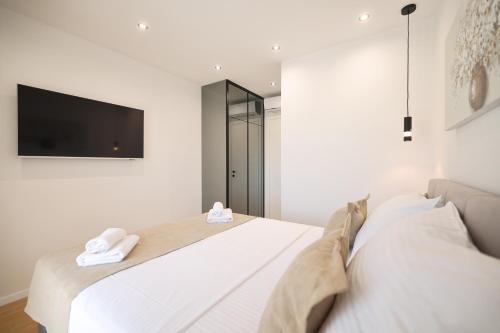 a bedroom with two beds and a flat screen tv at Leonardo Luxury Residence 2 Penthouse with jacuzzi in Zadar