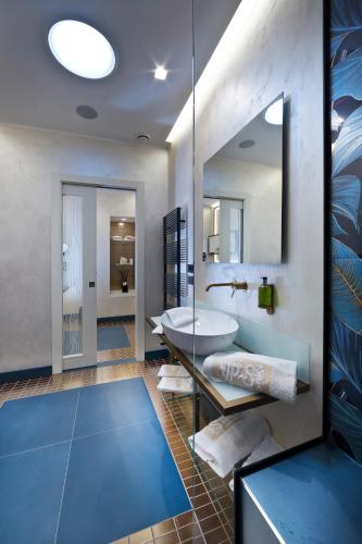 a bathroom with a tub and a sink and a mirror at Vip's Motel Luxury Accommodation & Spa in Lonato del Garda