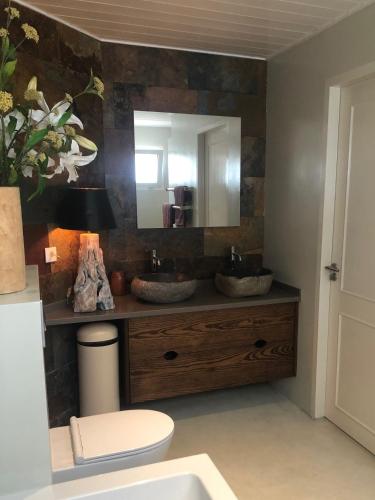 La salle de bains est pourvue de 2 lavabos et d'un miroir. dans l'établissement Villa at secured gated resort near Mambo Beach!, à Willemstad