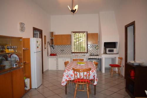 Il comprend une cuisine équipée d'une table, de chaises et d'un réfrigérateur. dans l'établissement La Cecia - Casa vacanze nella campagna salentina, à Cavallino di Lecce
