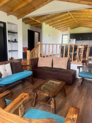 a living room with a couch and a table at Cabaña Campestre Montreal in Paipa
