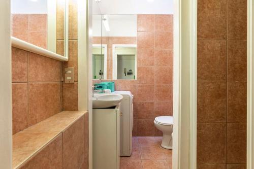 een badkamer met een toilet, een wastafel en een spiegel bij Grazioso in Milaan