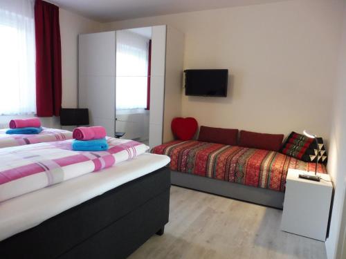 ein Hotelzimmer mit 2 Betten und einem Sofa in der Unterkunft Komfortable Wohnungen und Studio in Sankt Englmar in Sankt Englmar