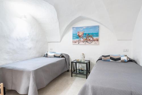 um quarto com duas camas e uma bicicleta na parede em Portici Guest House by Rentbeat em Fasano