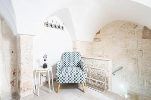 um quarto com uma cadeira e uma mesa em Portici Guest House by Rentbeat em Fasano