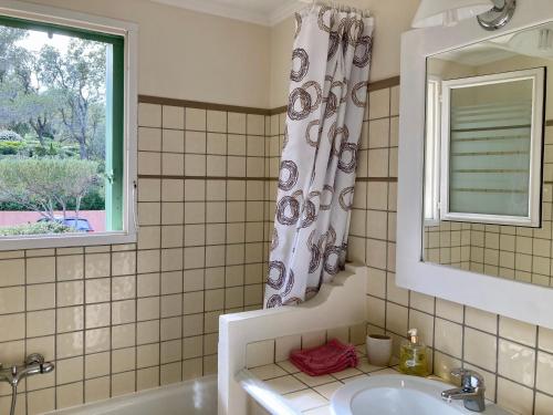łazienka z wanną, umywalką i oknem w obiekcie Les Restanques Maison 14 Chênes w mieście Grimaud