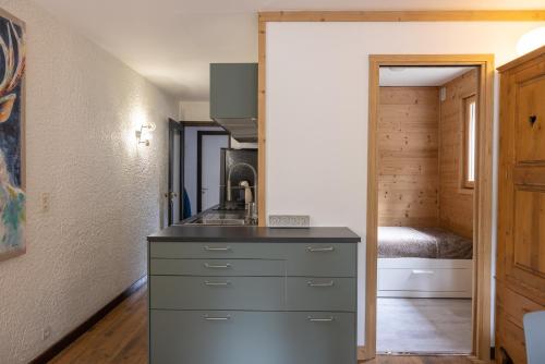 une cuisine avec un comptoir et une chambre avec un lit dans l'établissement Appartement 4 à 5 personnes, aux Contamines-Montjoie