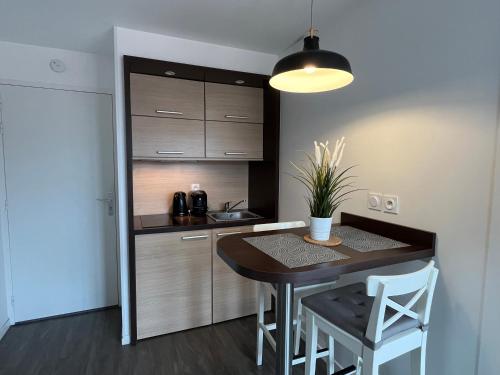 a kitchen with a table and chairs and a sink at Caph YourHostHelper in Caen