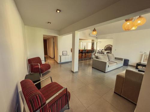 a living room with red chairs and a couch at Estancia Alto San Pedro in Huerta Grande