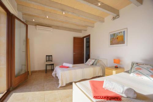 ein Schlafzimmer mit 2 Betten und einem Tisch in einem Zimmer in der Unterkunft Villa Antonia, Pollença in Pollença