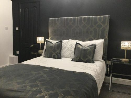 a bedroom with a large bed with black and white pillows at The Smithy in Hay-on-Wye