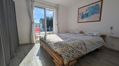 um quarto com uma cama e uma grande janela em Grempoup's Home em Saint-Gély-du-Fesc