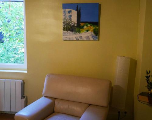 a living room with a couch and a picture on the wall at Maison charmante à Aignes avec jardin et barbecue in Aignes