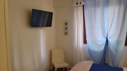 een slaapkamer met een bed en een televisie aan de muur bij Lighthouse Taranto in Taranto