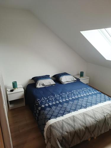 une chambre avec un lit avec des draps bleus et une fenêtre dans l'établissement Joli duplex le clos St Jacques, à Étampes