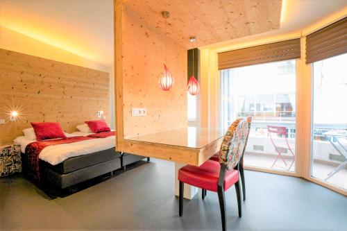 een slaapkamer met een bureau, een bed en een raam bij Hotel L'Esprit Sain in Malmedy