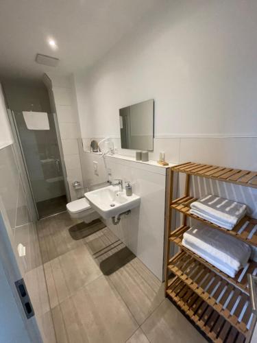 a white bathroom with a sink and a mirror at Urlaubshaus-Erzgebirge in Zwönitz